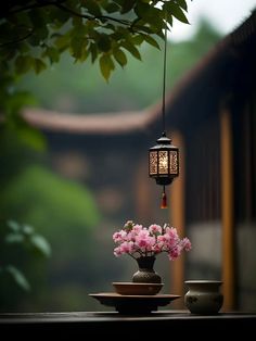 a vase filled with pink flowers sitting on top of a table next to a lamp