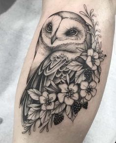 an owl with flowers and leaves on the thigh is shown in black and grey ink