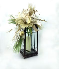 a lantern with flowers and greenery in it