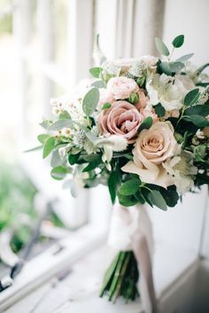 a bouquet of flowers sitting on top of a window sill