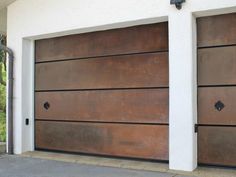 a brown garage door is open on the side of a house