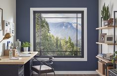 a home office with a mountain view out the window, and desk in front of it