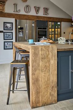 an island in the middle of a kitchen with stools