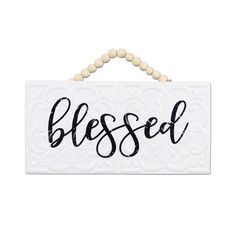 a white sign that says,'blessed'with beads hanging from the front of it