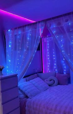 a bedroom decorated in purple and blue lights