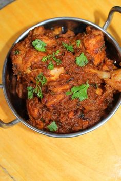 a metal pan filled with food on top of a wooden table