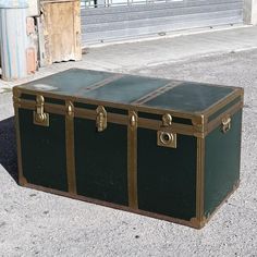 an old trunk sitting on the ground in front of a building with no people around it