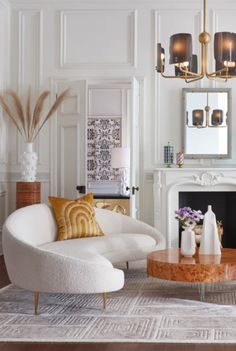 a living room filled with furniture and a fire place in front of a white fireplace