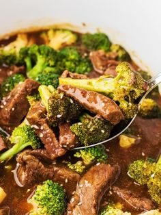 a spoon full of beef and broccoli with brown sauce