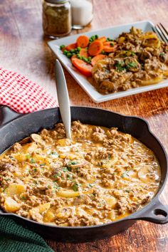 a skillet filled with food on top of a wooden table