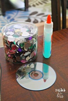 a glass container filled with coins next to a cd