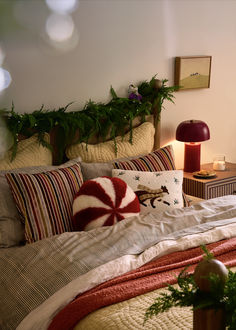 a bed with pillows and christmas decorations on it