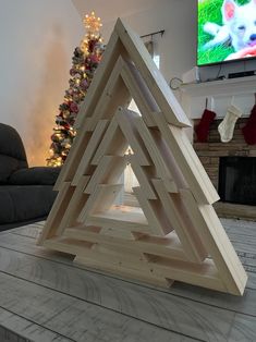 a christmas tree made out of wooden dows on top of a table in front of a tv