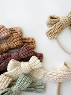 several knitted bow ties laid out on a white surface with one tied up and the other untied