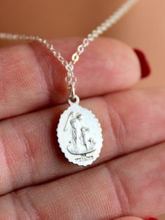 "Dainty sterling silver Saint Joseph charm necklace for women. This beautiful detailed oval charm is 925 sterling silver, measures 16x11 mm and comes on shiny 925 sterling silver cable chain with spring clasp. Image features Saint Joseph holding a baby Jesus. Reverse side shows and angel protecting a child. Model is wearing 16\" length in photos. Comes in many lengths. Comes in a gift box ready to present. CHOSE YOUR LENGTH." Silver Oval Pendant Necklace With Sterling Clasp, Silver Oval Pendant Necklace With Sterling Silver, Silver Sterling Silver Charm Necklace With Oval Pendant, Silver Sterling Oval Charm Necklaces, Silver Sterling Silver Oval Pendant Charm Necklaces, Silver Oval Pendant Charm Necklace In Sterling Silver, Silver Oval Sterling Silver Charm Necklace, Oval Silver Sterling Silver Charm Necklaces, Dainty Silver Charm Necklace With Oval Pendant