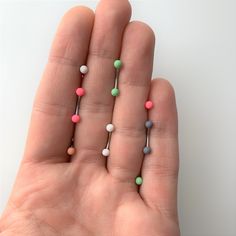 a person's hand holding several small beads