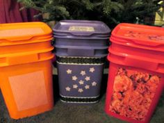 four plastic trash cans lined up next to a christmas tree