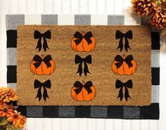 a door mat decorated with pumpkins and bows