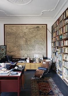 a living room filled with furniture and bookshelves covered in lots of bookcases