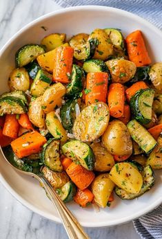 a white bowl filled with roasted vegetables on top of a table