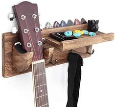 a guitar is hanging on the wall next to a rack with shoes and other items