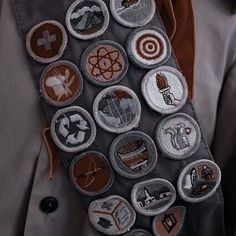 a man wearing a tie with many different badges on it's necktie,