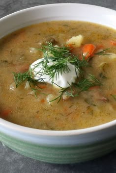 a white bowl filled with soup and topped with sour cream