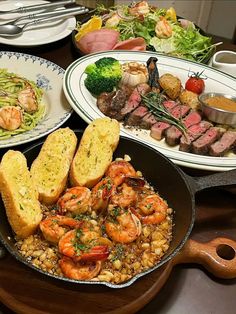 a table topped with lots of different types of food and plates filled with meats