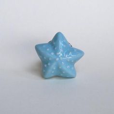 a small blue star shaped object on a white surface with tiny stars in the middle