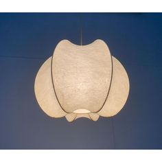 a white lamp hanging from the ceiling with a blue wall in the backround