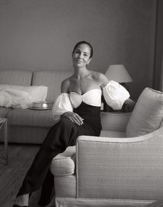 a woman sitting on top of a couch next to a lamp