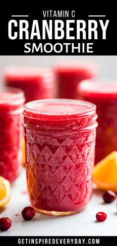 cranberry smoothie in a jar with oranges and cranberries around it