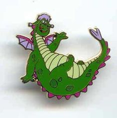 a green and purple dragon pin sitting on top of a white surface