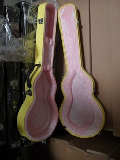 two pink and yellow guitar cases sitting next to each other