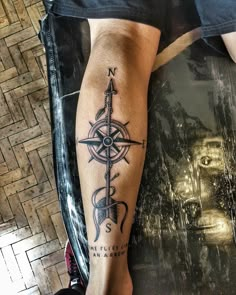 a man with a compass tattoo on his leg