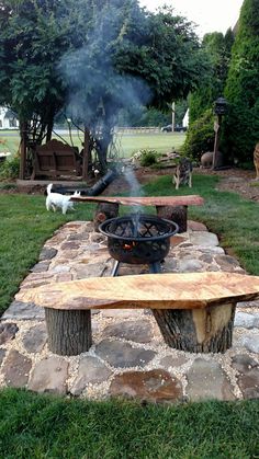 a fire pit sitting on top of a wooden bench in the middle of a park