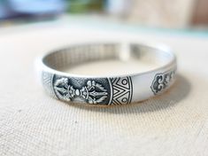 "This is a Tibetan mantra cuff bracelet with engraving of Vajra Symbol, Om Mani Padme Hum mantra and The Heart Sutra. 999 fine silver is as close as you can get to pure silver. Because this meditation bangle consists of 99.9% pure silver, it is highly resistant to tarnish. Vajra is a symbolic ritual tool that is used in Buddhism, Hinduism, and Jainism to represent the unyielding power of spirit. It is a Sanskrit word that means 'thunderbolt'. Vajra is a classic symbol, symbolizes the striking an Symbolic Bangle Bracelet For Meditation, Symbolic Engraved Adjustable Cuff Bracelet, Symbolic Etched Bracelets As Gift, Adjustable Engraved Symbolic Cuff Bracelet, Symbolic Etched Bracelets For Gift, Engraved Adjustable Symbolic Cuff Bracelet, Symbolic Etched Bracelet As Gift, Engraved Symbolic Adjustable Cuff Bracelet, Handmade Silver Spiritual Wristband