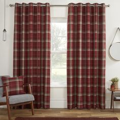 a living room with red plaid curtains and a chair