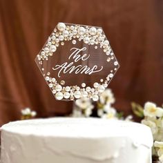 a wedding cake with an acrylic topper that says the vows on it