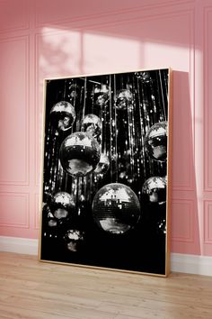 a black and white photo of disco balls hanging from the ceiling in a room with pink walls