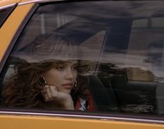 a woman sitting in the passenger seat of a car talking on her cell phone