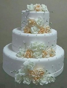 three tiered wedding cake with white and peach flowers