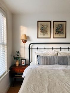 a bedroom with two framed pictures above the bed