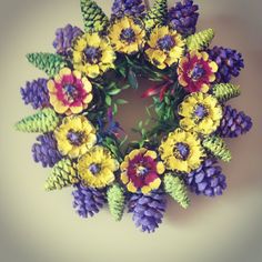 a wreath made out of pine cones and flowers