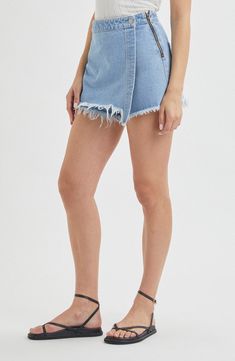 Keep it carefree and kicked back when you choose a look that combines the comfort of cutoff shorts with the cuteness of a denim mini. 3 1/2" inseam; 26" leg opening; 12" front rise; 14 1/2" back rise (size 29) 15" length (size 29) Exposed side-zip closure; wrap front with button Back patch pockets 100% cotton Machine wash, line dry Imported Spring Denim Skort With Built-in Shorts, Denim Skort With Built-in Shorts For Spring, Trendy Light Wash Cutoff Mini Skirt, Denim Mid-rise Summer Skort, Mid-rise Denim Skort For Summer, Summer Mini Bottoms With Frayed Hem, Denim Skort With Built-in Shorts For Summer, Summer Denim Skort For Day Out, Summer Mini Length Bottoms With Frayed Hem