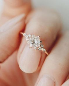 a woman's hand holding an engagement ring