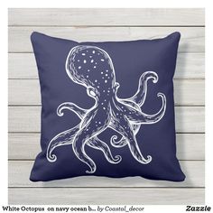 an octopus pillow sitting on top of a wooden floor next to a white plank wall