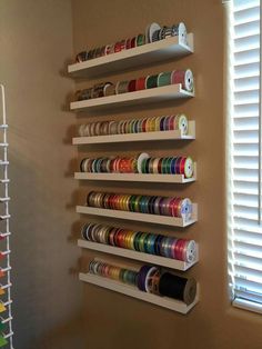 the wall is filled with many different types of thread and spools on it