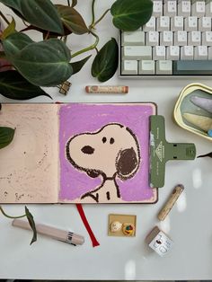 an open notebook with a drawing of a dog on it next to some pens and pencils