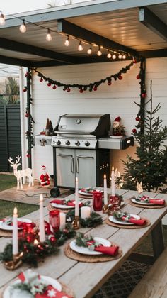 an outdoor table with christmas decorations and candles